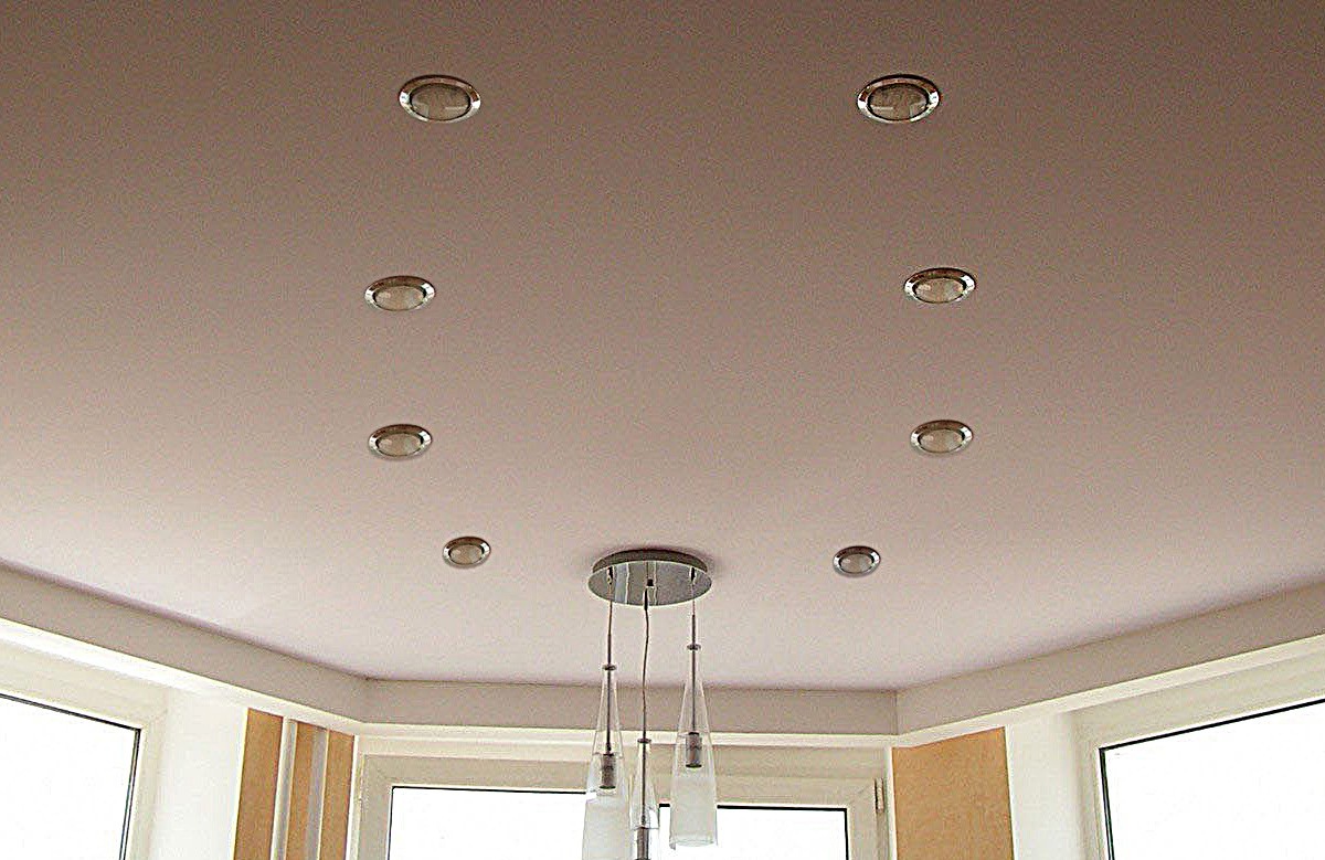 Кремовый матовый натяжной потолок с восемью светильниками и люстрой
