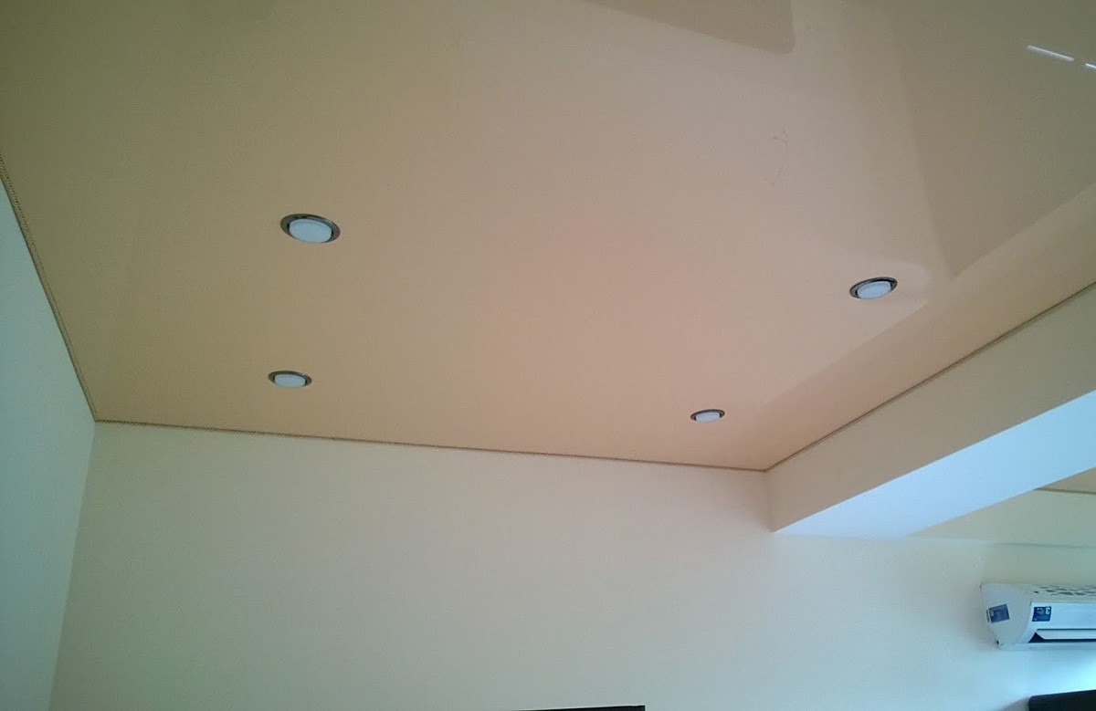 Кремовый глянцевый натяжной потолок с четырьмя светильниками