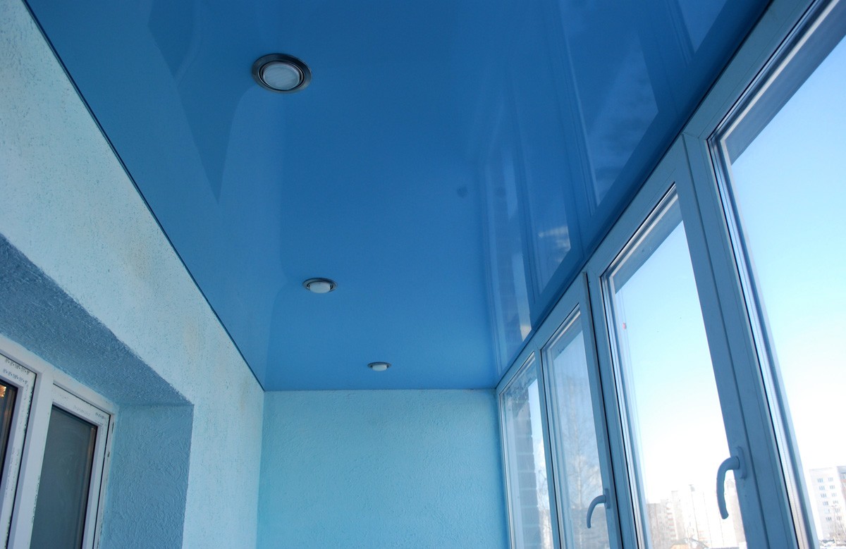 Голубой глянцевый натяжной потолок со светильниками на балконе