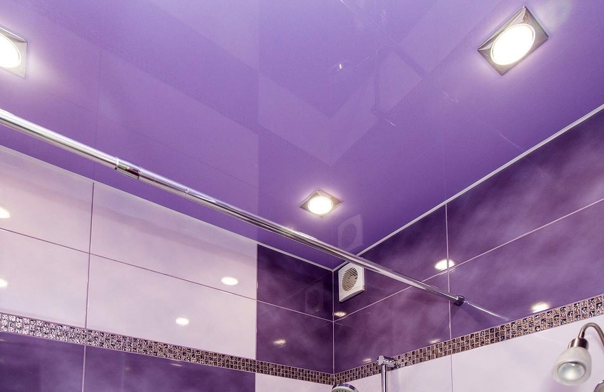 Сиреневый глянцевый натяжной потолок с квадратными светильниками в ванной