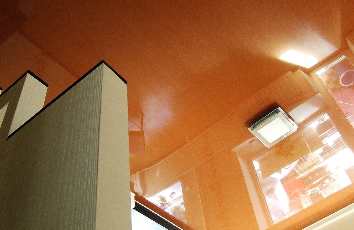Оранжевый глянцевый натяжной потолок с люстрой