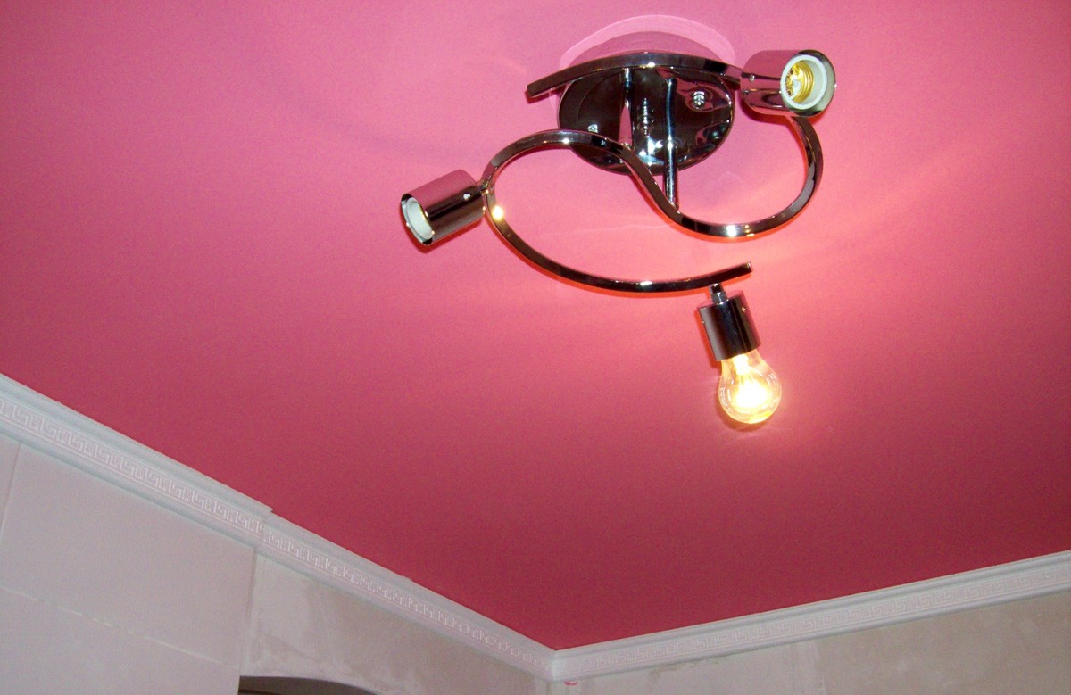 Розовый сатиновый натяжной потолок с люстрой