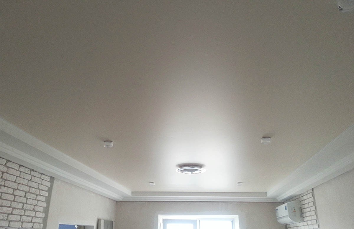 Сатиновый натяжной потолок цвета ванили в комнате