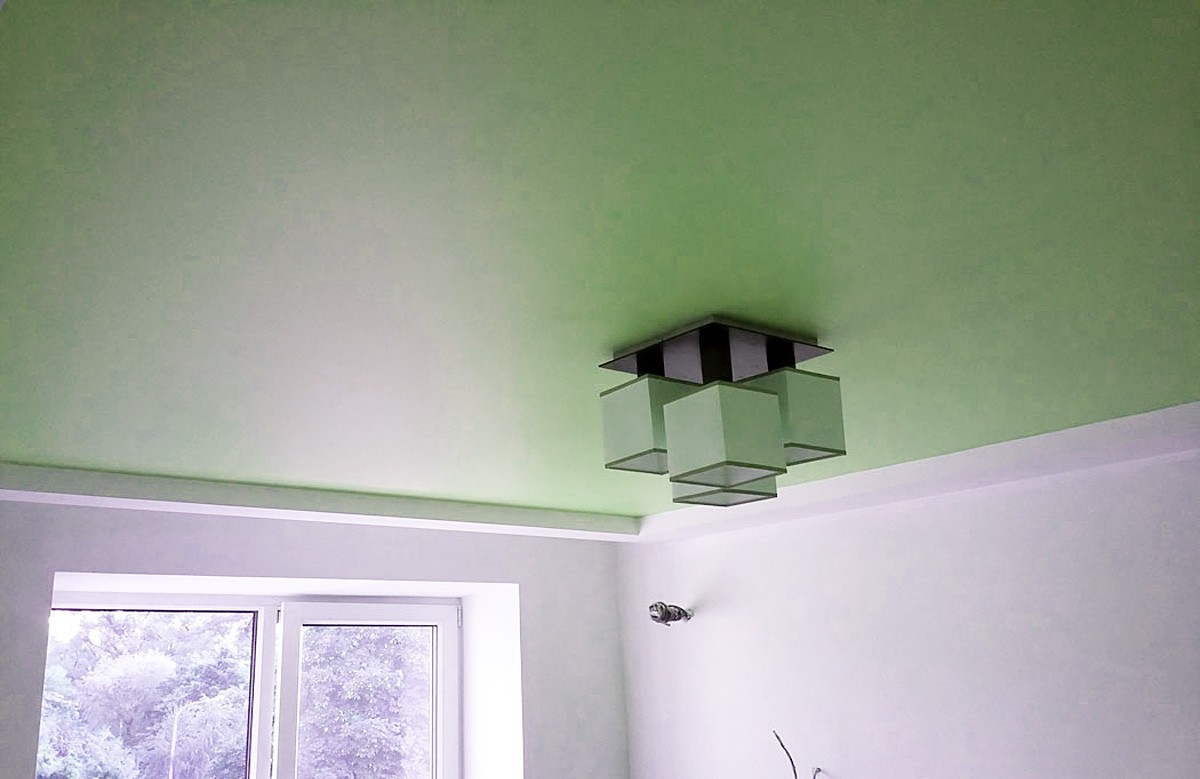 Зелёный сатиновый натяжной потолок с люстрой